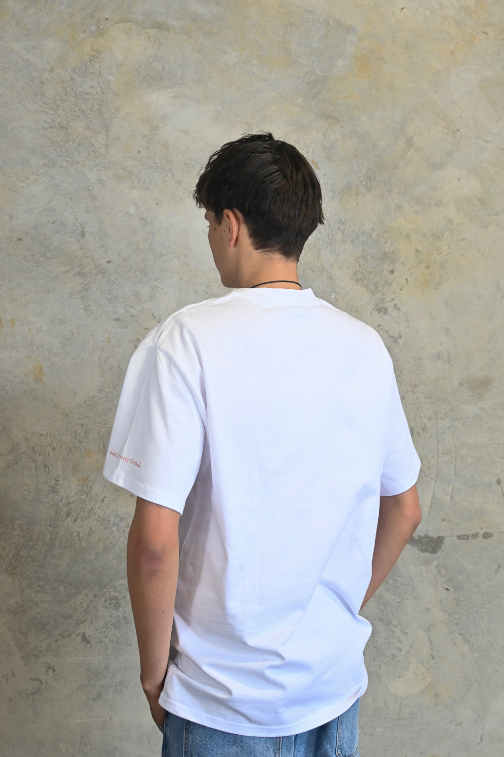 Back view of white oversized streetwear tee in premium heavyweight cotton