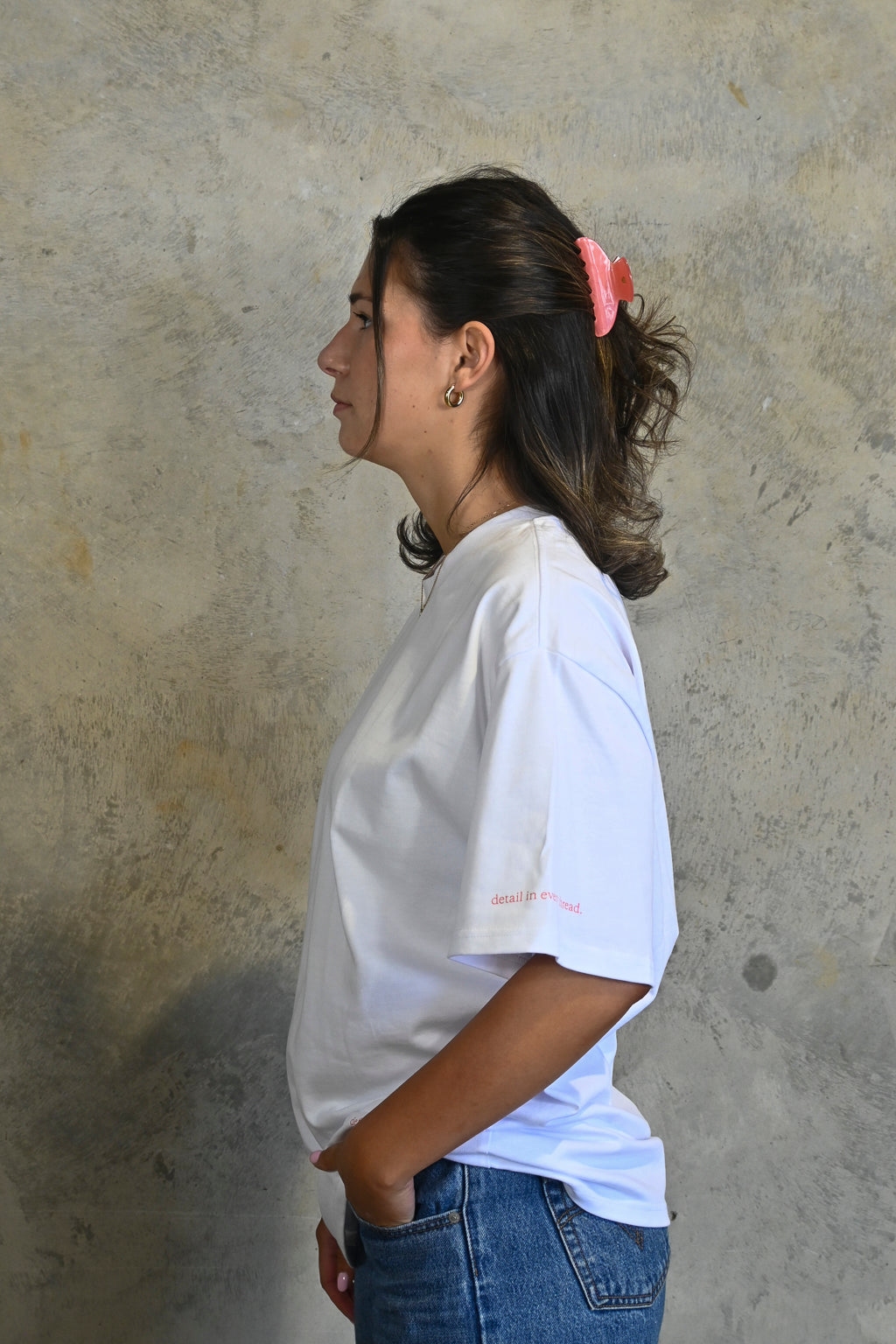 Right sleeve print reading detail in every thread in pink on white tee