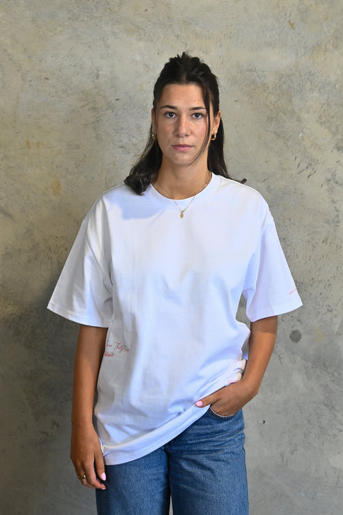 Model wearing white oversized heavy tee by Thirty Four Thirty Four with pink logo print
