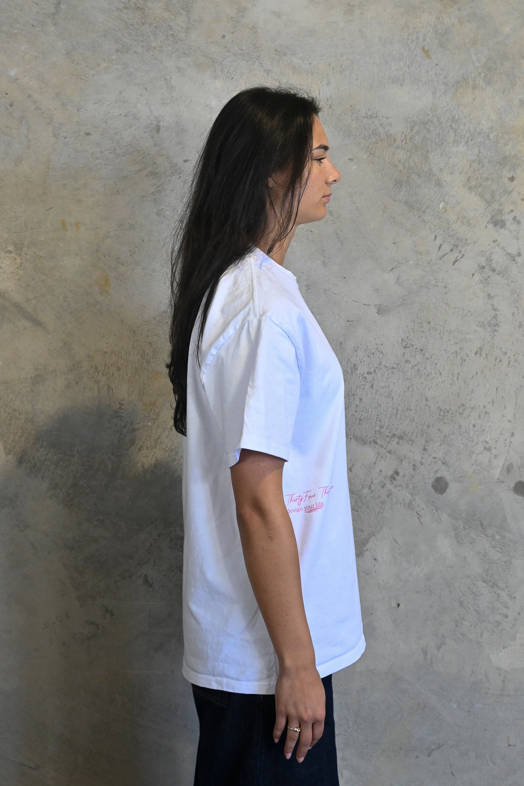 Female model styling white and pink oversized streetwear tee from Thirty Four Thirty Four