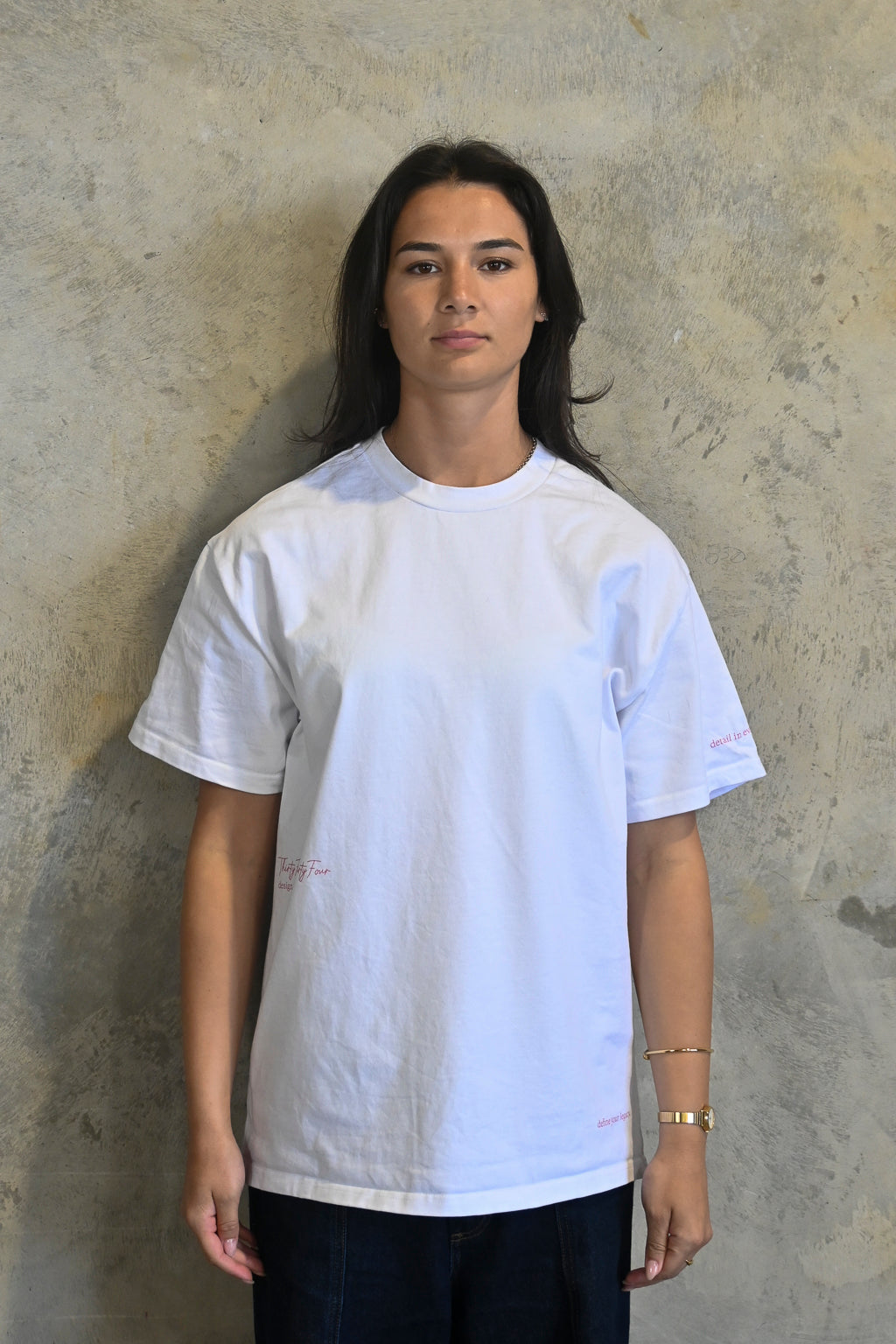 Model wearing white oversized heavy tee by Thirty Four Thirty Four with pink logo print