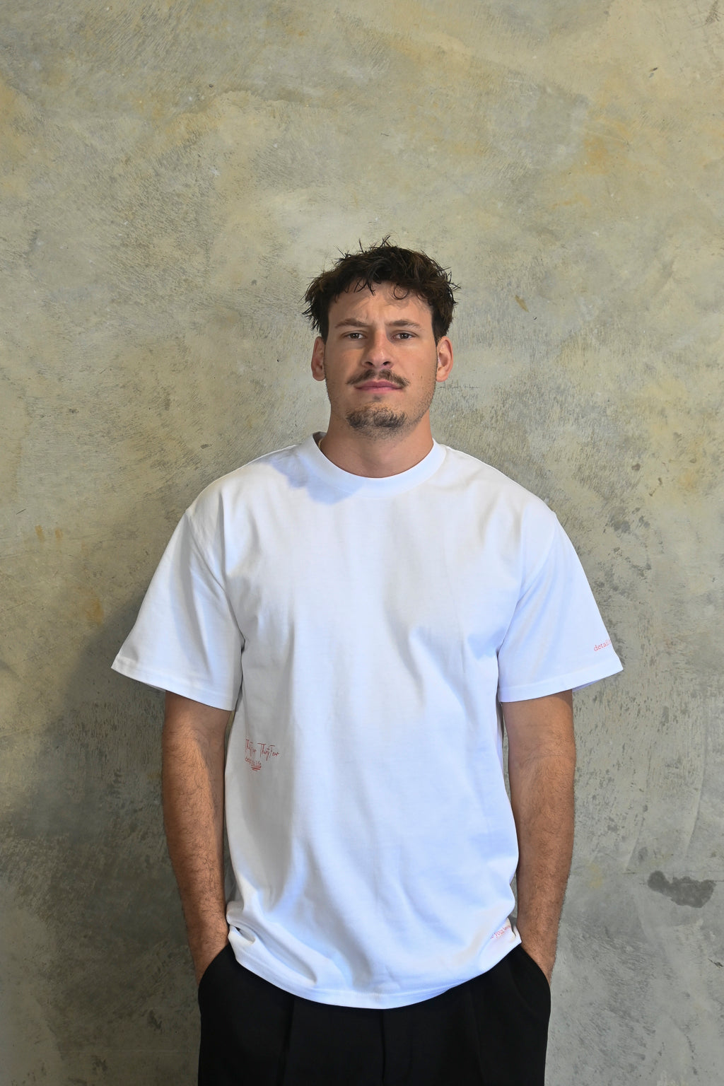 Male model styling minimalist white and red oversized streetwear tee